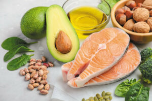 Salmon, avocado, nuts, and oil arranged on a white background 