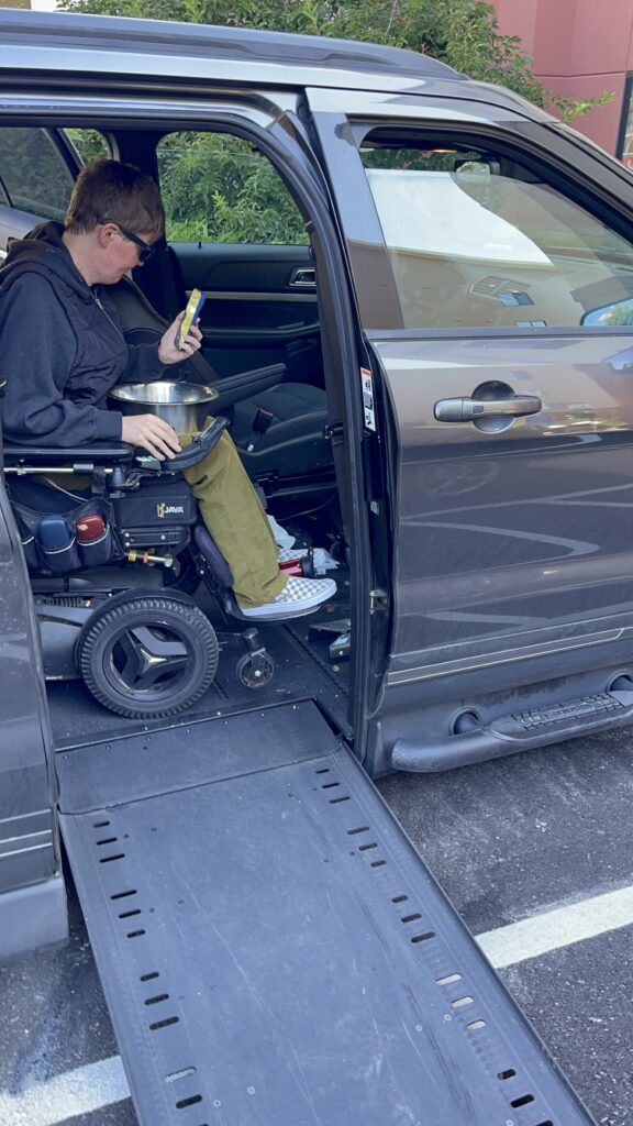 A man in a wheelchair enters a car via ramp